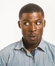 Young dark-skinned man makes surprised face looking to the left at copy space. Surprised African American male head Royalty Free Stock Photo