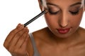 Young dark skinned woman applying eyeshadow Royalty Free Stock Photo