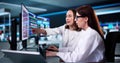 Young data scientist and manufacturing researcher using multiple computers