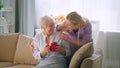 Young daughter giving a present to a elderly mother Royalty Free Stock Photo