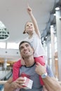 Young daughter points and sits on fathers shoulders Royalty Free Stock Photo