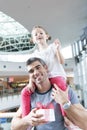 Young daughter sits on fathers shoulders Royalty Free Stock Photo