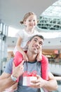 Young daughter sits on fathers shoulders Royalty Free Stock Photo