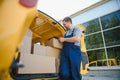 young delivery man courier in uniform hold documents clipboard checking list parcel post boxes near a car for service Royalty Free Stock Photo