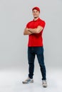 Young delivery man smiling while posing with arms crossed Royalty Free Stock Photo