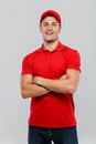 Young delivery man smiling while posing with arms crossed Royalty Free Stock Photo