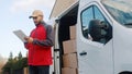 Young delivery man using tablet to find the address and deliver parcel Royalty Free Stock Photo