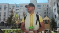 Young delivery man in yellow uniform with takeaway coffee, looking at camera and smile and waiting for customer Royalty Free Stock Photo