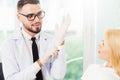 Young dentist talks with patient in dental clinic.