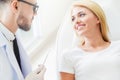 Young dentist talks with patient in dental clinic.