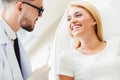 Young dentist talks with patient in dental clinic.