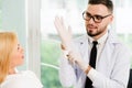 Young dentist talks with patient in dental clinic.