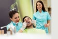 Dentists examining and working on male patient.Dentist`s office.