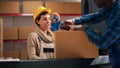 Young depot worker putting adhesive tape on packages