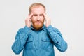 Young depressed bearded man touching his temples and having headache