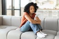 Young Depressed Black Woman Sitting On Couch And Looking At Smartphone Screen Royalty Free Stock Photo