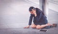 Young depressed businesswoman sitting on the floor