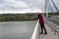 Young depressed homeless girl or woman standing alone on the bridge want to jump in the water of the river and to commit suicide