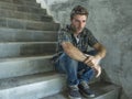 Young depressed and sad man sitting alone outdoors on dark street staircase suffering depression problem looking worried thinking Royalty Free Stock Photo