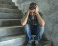 Young depressed and sad man sitting alone outdoors on dark street staircase suffering depression problem looking worried thinking Royalty Free Stock Photo
