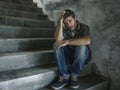 Young depressed and sad man sitting alone outdoors on dark street staircase suffering depression problem looking worried thinking Royalty Free Stock Photo