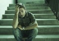 Young depressed and sad man sitting alone outdoors on dark street staircase suffering depression problem looking worried thinking Royalty Free Stock Photo