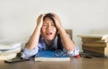 Young depressed and stressed Asian Chinese student girl working with laptop and book pile overwhelmed and frustrated preparing