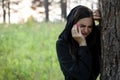 A young depressed woman is sad by a tree in the Park. girl is crying Royalty Free Stock Photo