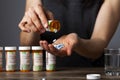 A young depressed woman is taking pills out of the medication bottle