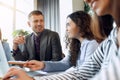 Young designer giving some new ideas about project to his partners in conference room. Business people discussing over Royalty Free Stock Photo