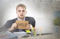 Young desperate businessman holding help sign looking worried suffering work stress at computer desk Royalty Free Stock Photo