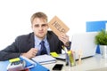 Young desperate businessman holding help sign looking worried suffering work stress at computer desk Royalty Free Stock Photo