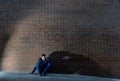 Young desperate jobless man who lost job lost in depression sitting on ground street corner Royalty Free Stock Photo