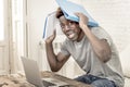 Young desperate and overwhelmed black afro American student man in stress at home working stressed with laptop computer worried an Royalty Free Stock Photo