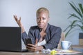 Young desperate and stressed african american business woman working at laptop computer desk at office suffering stress problem us Royalty Free Stock Photo