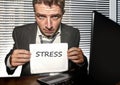 Young desperate and stressed business man working overwhelmed at office computer desk feeling helpless and overworked holding Royalty Free Stock Photo