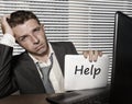 Young desperate and stressed business man working overwhelmed at office computer desk feeling helpless and overworked holding Royalty Free Stock Photo