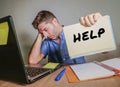 young desperate and stressed businessman feeling overwhelmed working with laptop computer at office desk sad suffering stress ask Royalty Free Stock Photo