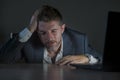 Young desperate and stressed businessman working overtime at office laptop computer desk feeling anxious and overwhelmed suffering Royalty Free Stock Photo