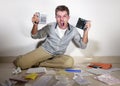 Young desperate and stressed sad man worried holding calculator accounting domestic payments and debt having money problem domesti Royalty Free Stock Photo