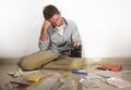 Young desperate and stressed sad man worried holding calculator accounting domestic payments and debt having money problem sitting Royalty Free Stock Photo