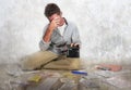 Young desperate and stressed sad man worried holding calculator accounting domestic payments and debt having money problem sitting Royalty Free Stock Photo