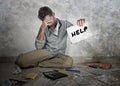 Young desperate and stressed sad man worried holding notepad asking for help accounting domestic payments and debt Royalty Free Stock Photo