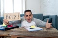 Young desperate student in stress working and studying holding a help sign Royalty Free Stock Photo