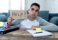 Young desperate student in stress working and studying holding a help sign Royalty Free Stock Photo