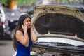 Upset Asian Chinese woman in stress stranded on street suffering car engine failure having mechanic problem calling on mobile Royalty Free Stock Photo
