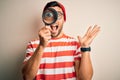 Young detective man looking through magnifying glass over isolated background very happy and excited, winner expression Royalty Free Stock Photo