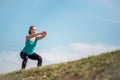 Young determined woman exercising squats outdoors Royalty Free Stock Photo
