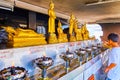 The young devotee making ritual pouring oil into oil lamps in small Altar of City Pillar Shrine in Bangkok, Thailand