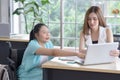 Young disabled Asian businesswoman working together with her colleague in workplace Royalty Free Stock Photo